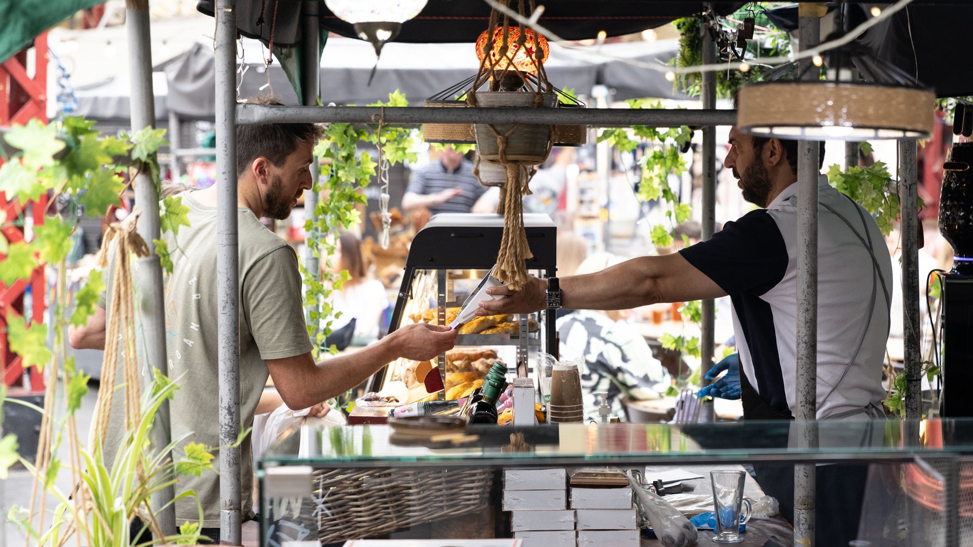 Trader selling goods to a customer in Altincham Market, Manchester