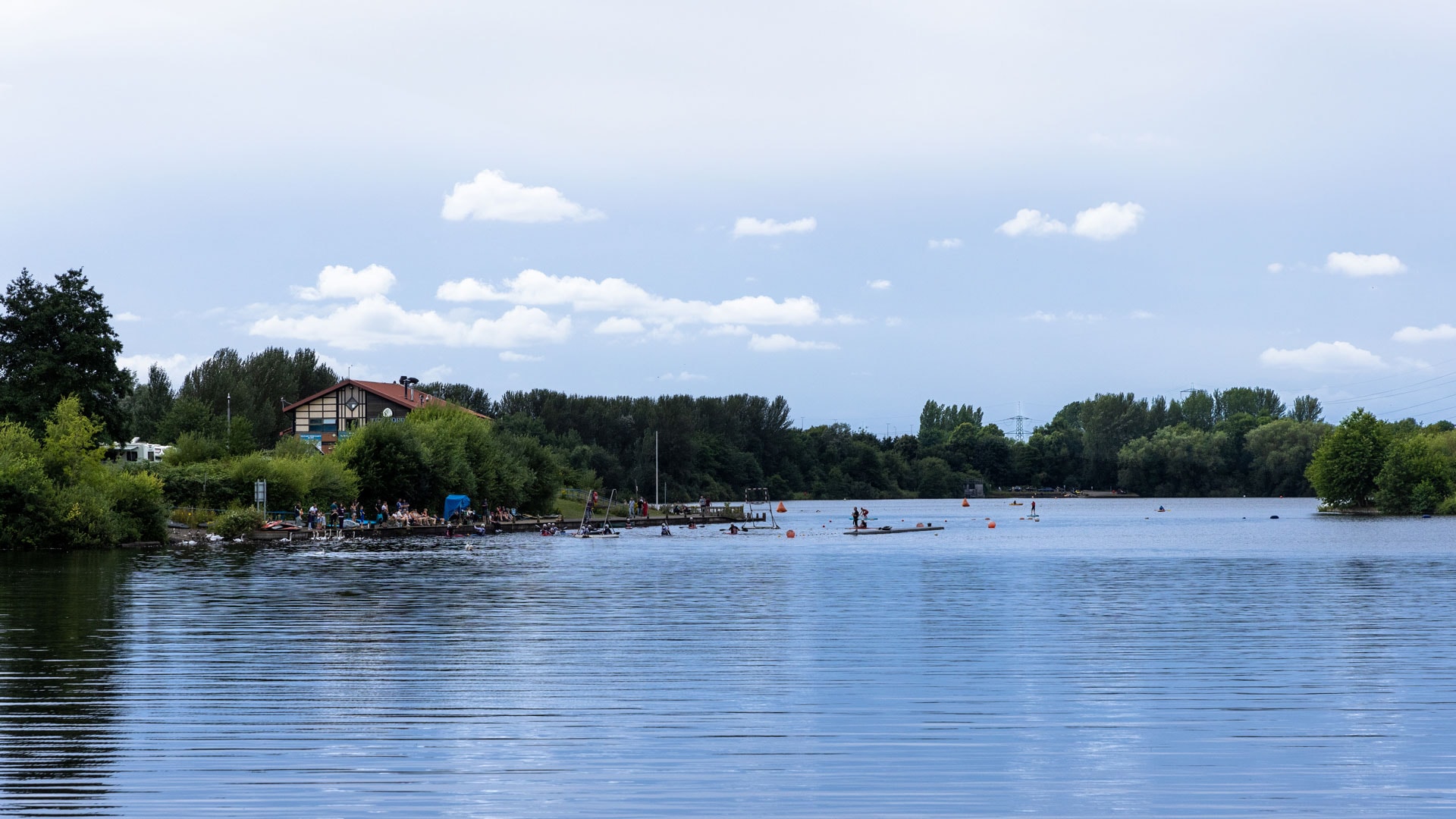 A view across the lake to a boathouse at Sale Water Park, Manchester